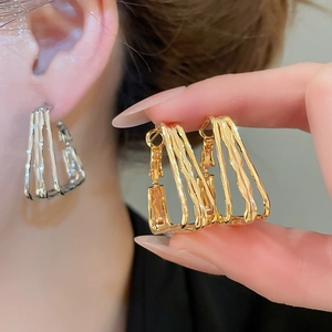 Detail showing 18k gold plated triple-layer wave square hoop earrings with texture