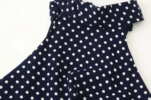 Macro shot of navy blue polka dot fabric showing detailed twill texture and stitching