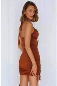Detail view of adjustable side drawstrings and ruched texture on halter neck dress