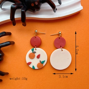 Halloween pumpkin polymer clay earrings with festive orange and cream circular designs