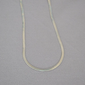 Detailed close-up showing the sleek texture and weave of the flat silver snake chain