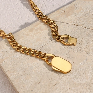 Polished gold stainless steel chunky link chain necklace on textured stone plate