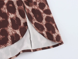Detailed close-up of leopard print shirt hem with side slit and quality stitching