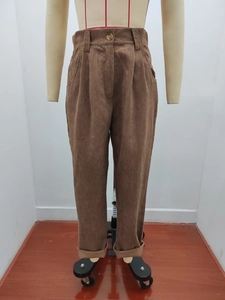 Detail der Cordhose mit hoher Taille, brauner Rippstruktur und Knopfverschluss am Bund