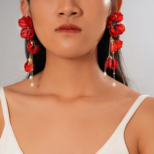 Übertriebene rote Stoffblumen-Ohrringe mit weißen Perlen am Model im Studio