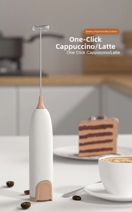 Detail of hand-held electric milk frother with stainless steel whisk and battery-powered motor