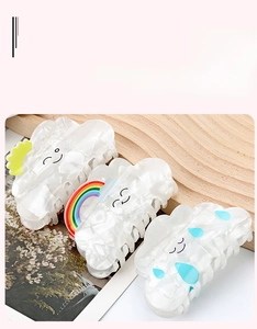 Three-piece set of cream white hair claws featuring sun, rainbow, and rain cloud designs