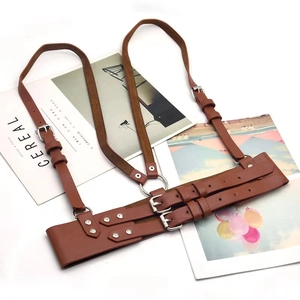 Detail view of brown faux leather harness with silver buckles and adjustable straps