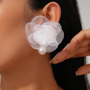 Détail d'une boucle d'oreille fleur en tissu blanc avec perle sur mannequin pour l'été