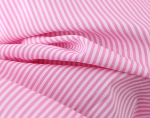 Primo piano della trama del tessuto di cotone a righe rosa e bianche con pieghe