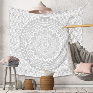 Détail d'une tapisserie mandala grise et blanche sur mur avec décor bohème chic
