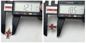 Detailed measurement of a golden cross pendant with red gemstones using a digital caliper
