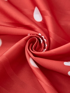 Detail of red Christmas snowman curtain fabric with white polka dots and silky texture