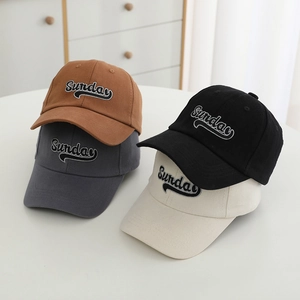 Detailed close-up of four colored cotton baseball caps with Sunday letter embroidery