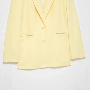 Women's pale yellow long sleeve blazer with notched lapels and double-button closure