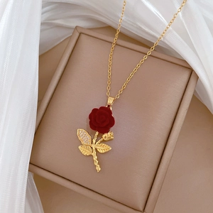 Luxury rose necklace in gold with red flower pendant and crystal leaf in a jewelry box
