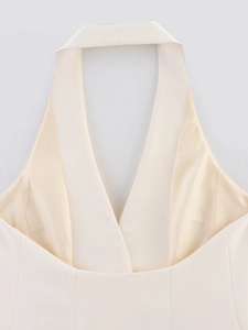 Detailed close-up of cream woven halter neckline showing high-quality fabric texture