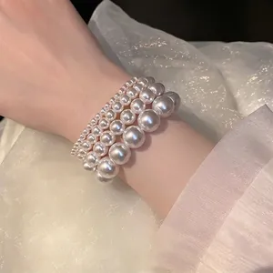 Elegant four-piece set of French vintage pearl elastic bracelets worn on a wrist