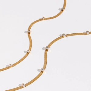 Elegant gold snake chain necklace with rectangular clear zircon stones on white background