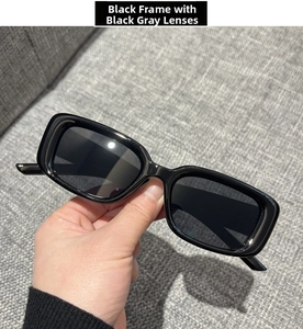 Detail shot of square black frame sunglasses with dark grey lenses and minimalist design