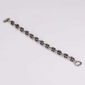 Detailed view of silver skull link bracelet with vintage finish and toggle clasp