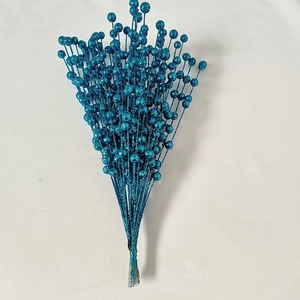 Detail of blue glitter berry stems for Christmas decor on white background