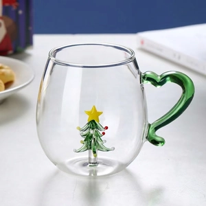 Macro view of clear glass mug with 3D Christmas tree and green heart-shaped handle