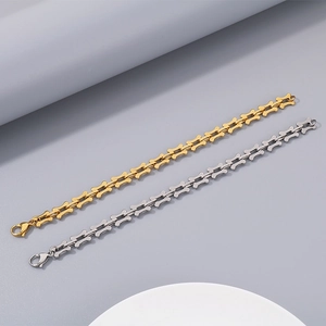 Detailed view of gold and silver bone-shaped link bracelets in polished titanium steel