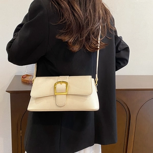 Close-up of beige lychee texture leather shoulder bag with elegant gold metal buckle