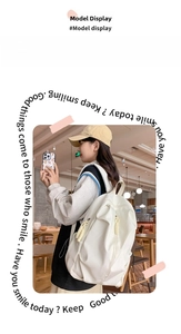 Large white minimalist backpack shown on 165cm model in a bright café setting