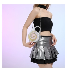 Detail of creative clock-shaped mini bag with white dial and silver chain strap