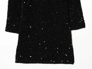 Macro shot of high-quality black sequin fabric detail on a stylish fashion dress