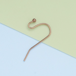 Macro detail of rose gold 304 stainless steel ball-end ear hook jewelry component