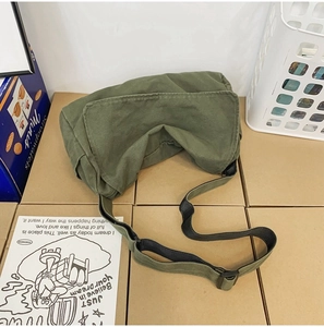 Detail view of the green washed canvas messenger bag with adjustable dark shoulder strap