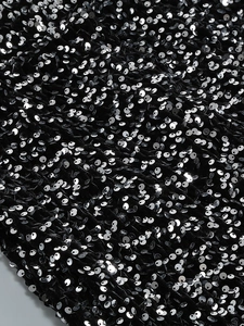 Détail de paillettes argentées sur tissu en velours noir pour robe de soirée