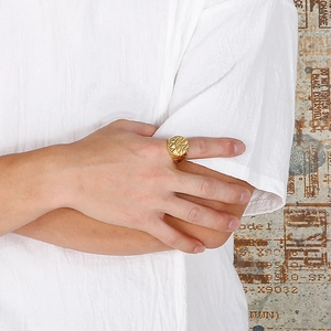 Close-up of men's gold stainless steel signet ring with geometric textured facet design