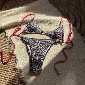 Detail of red and black checkered bikini with smocked texture and white pearl bead accents