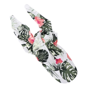 Detailed close-up of white headwrap fabric with green tropical leaves and pink floral print
