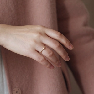 Close-up of minimalist 18K gold heart-shaped zircon ring worn on a finger
