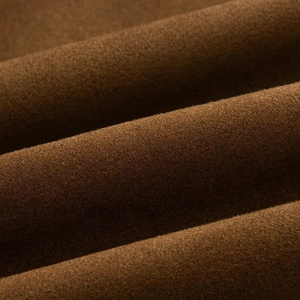Macro shot of dark brown faux suede fabric texture on a vintage biker jacket