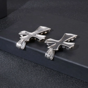 Macro shot of silver stainless steel cross pendants with skull details on dark display