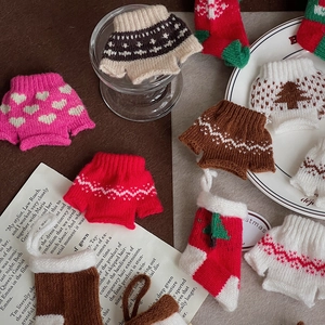Detailed close-up of mini knitted Christmas sweater and sock decorations for DIY crafts