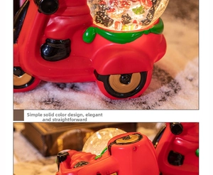 Détail d'une boîte à musique de Noël en forme de scooter rouge avec boule à neige et boîtier pile