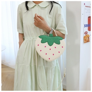Detail of strawberry-shaped crossbody bag with green sequins and pink embroidery