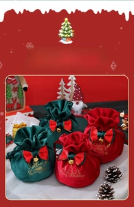 Detail view of velvet Christmas gift bags with gold foil text and festive ribbons