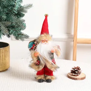 Standing Santa Claus doll with red hat and gift bag by a golden Christmas tree