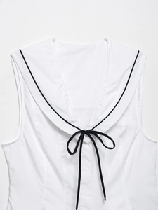 Detail of white sleeveless top featuring sailor collar and black bow tie ribbon