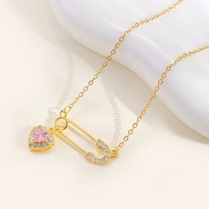 Titanium gold necklace with pink heart gemstone and sparkling safety pin pendant detail
