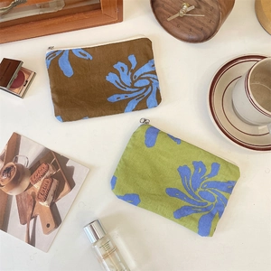 Detailed view of two fabric zipper pouches with abstract floral patterns and canvas texture