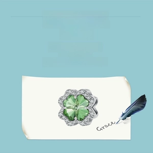 Detail of s925 silver four-leaf clover charm with green stones and zircon inlay